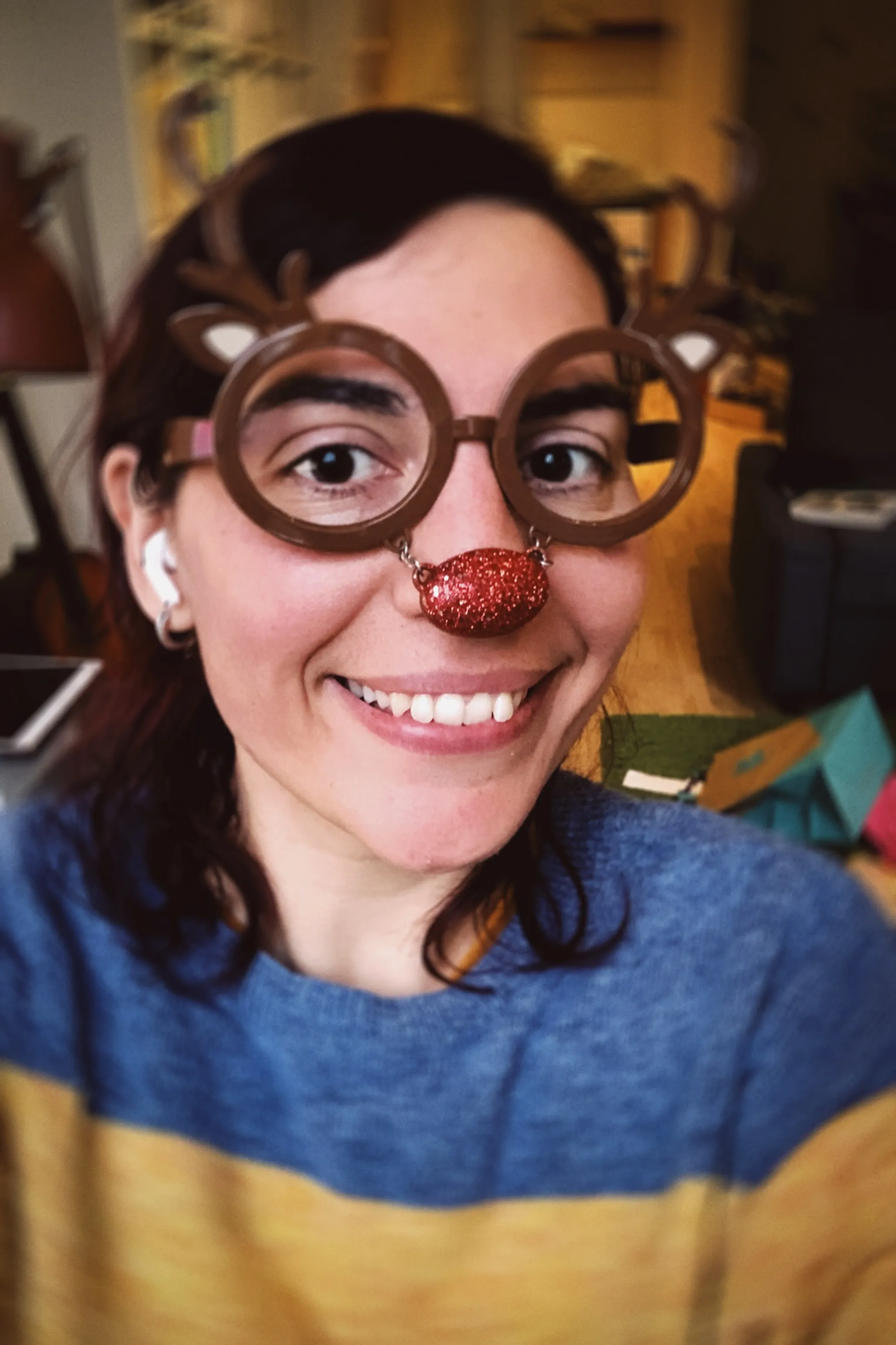 A selfie of me wearing a pair of reindeer glasses: those are brown with antlers coming off the eyes and a red nose linked to them by a short chain.