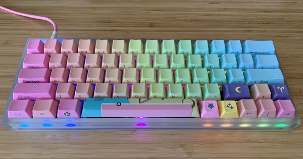 A compact 60% mechanical keyboard, with a transparent acrylic case, and rainbow side printed keycaps.